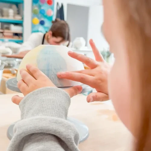 Niño concentrado pintando pieza de cerámica – beneficios emocionales Niño concentrado pintando pieza de cerámica – beneficios emocionales